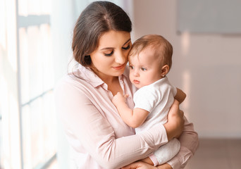 Happy mother with cute little baby at home