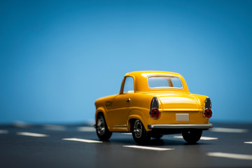 Yellow toy car on a blue background.