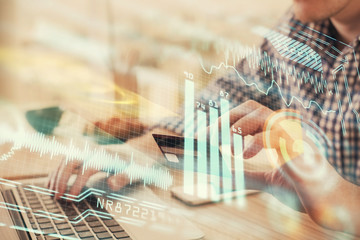 Double exposure of man hands holding a credit card and tech theme drawing. Technology in E-commerce concept.