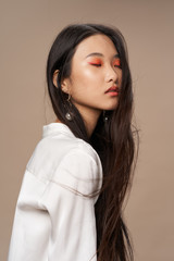 Fototapeta Pretty woman of Asian appearance makeup luxury charm beige background obraz