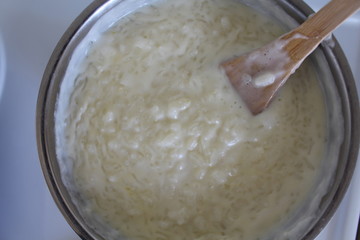 Cooking of rice porridge on oven, the first stage of preparation of national Finnish dish from rye flour and rice - Karelian pies