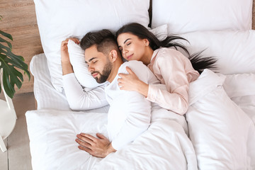 Young couple sleeping in bed at home