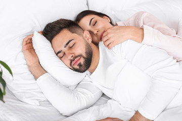 Young couple sleeping in bed at home