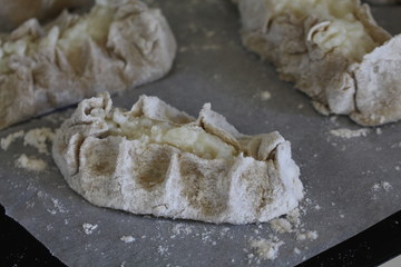 Cooked Karelian pies - Pirakka on a baking sheet. Dish of national cuisine - piirakka. Close-up.