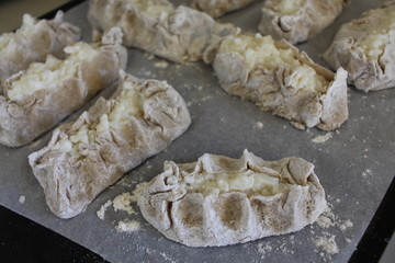 Cooked Karelian pies - Pirakka on a baking sheet. Dish of national cuisine - piirakka. Close-up.