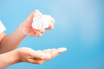 young woman applying drop dispenser sanitizer alcohol gel on hand