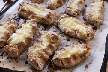 Cooked Karelian pies - Pirakka on a baking sheet. Dish of national cuisine - piirakka. Close-up.