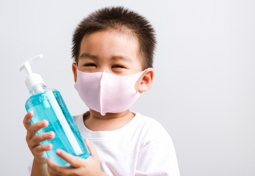 little child boy holding show bottle pump dispenser sanitizer alcohol gel