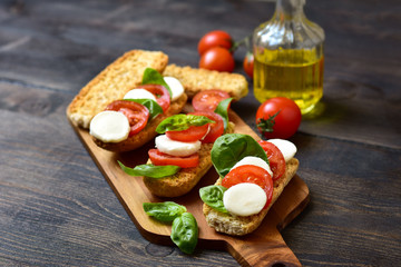 bruschetta with tomatoes, mozzarella and Basil, Caprese salad on toast. typical Italian antipasti starter in a restaurant in Italy Rome Milan. tomato bruschetta recipe, selective focus