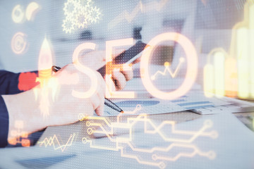 Multi exposure of man's hands holding and using a digital device and seo drawing. search...