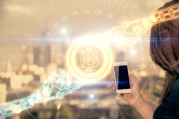 Double exposure of blockchain business sketch hologram and woman holding and using a mobile device.