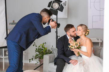 Photographer working with young wedding couple in studio