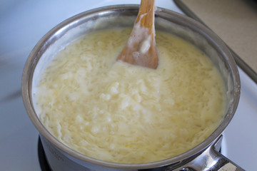 Cooking of rice porridge on oven, the first stage of preparation of national Finnish dish from rye flour and rice - Karelian pies