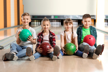 Little children playing bowling in club