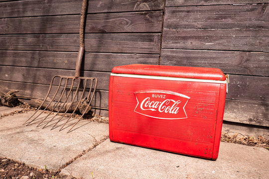 Vintage Red Classic French Buvez Coca Cola Cooler From 1964. Retro Rural Farm Setting.