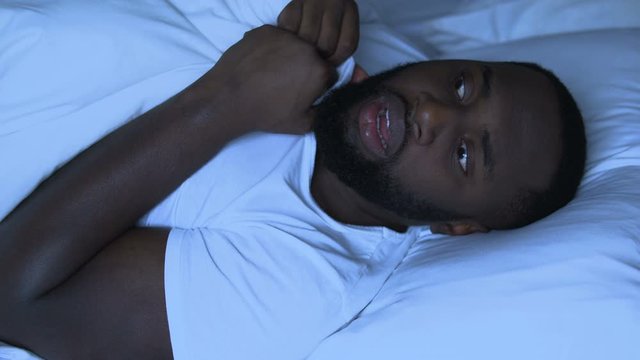 Impressionable african american man suffering from bad dreams and nightmares