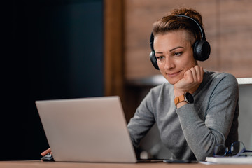 Woman using laptop and listening music at home