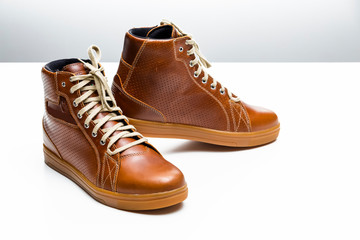 Pair of New Leather Tan Motorcyclist Boots Against White Background.