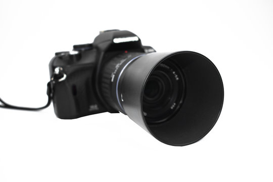 Front view of a black colored camera with lens attached to it placed on a white background
