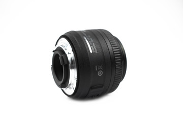 Fototapeta na wymiar One black color camera lens of a digital camera placed over a white background