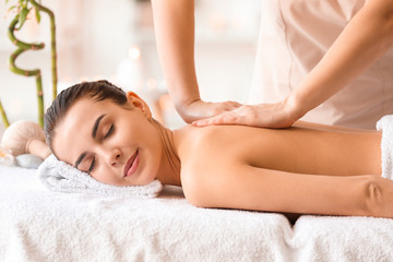 Fototapeta na wymiar Beautiful young woman receiving massage in spa salon