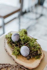 Home table decor. Festive table composition for traditional holiday dinner, decorated with moss, eggs, spring flowers. Happy easter concept