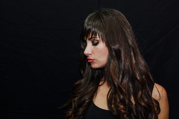 Long-haired brunette woman on black background