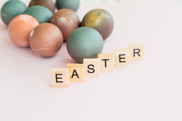 Happy уaster eggs. Word EASTER written on Scrubble letters  on pink background