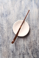  Chashaku Matcha spoon and empty ceramics plate on rustic wooden background. Symbolic image. Asian culture. Top view. Copy space.