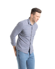 Young man suffering from hemorrhoids on white background