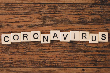 tiled letters spell coronavirus - unevenly spaced to create tension