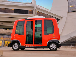 Bright red electric mini bus offering free transport to pedestrians