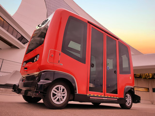 Bright red electric mini bus offering free transport to pedestrians