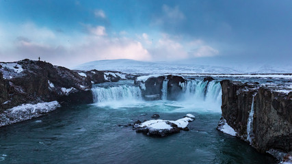 Godafoss Waterfall at sunset in a snowstorm, Northern Iceland, Europe. It is located along the country's main ring road at the junction with the Sprengisandur highland road.