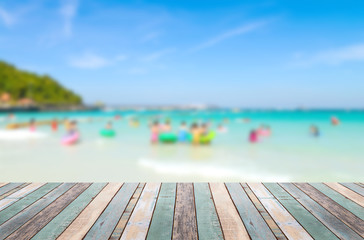 Wood table top with blurred people at the beach