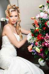 beauty young bride alone in luxury vintage interior with a lot of flowers, makeup and creative hairstyle