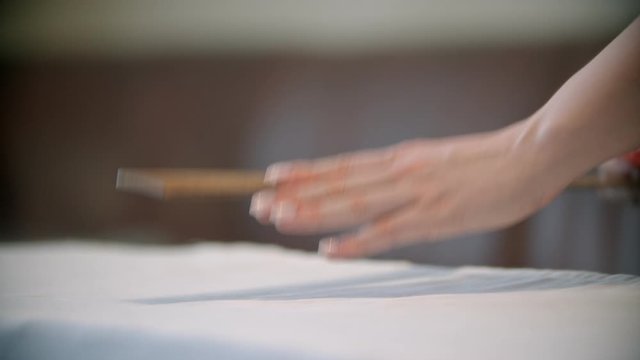 Young woman seamstress making marks using the soap on the cloth