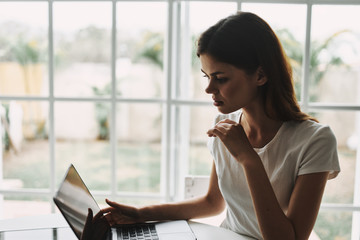 Woman at home in front of laptop chatting vacation