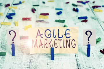 Conceptual hand writing showing Agile Marketing. Concept meaning focusing team efforts that deliver value to the endcustomer Crumbling sheet with paper clips placed on the wooden table
