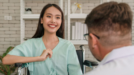 Obraz premium asian woman patient feeling happy with visit from caucasian man doctor at hospital