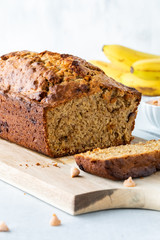 A freshly baked banana bread loaf with butterscotch chips sliced into and ready for eating.
