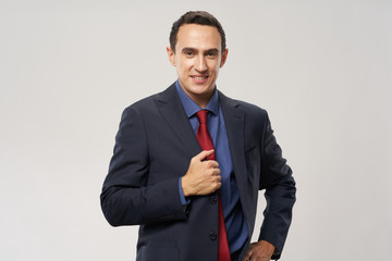 The guy has a red tie and a jacket with a blue shirt