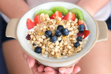 Hand of woman holding bowl of fresh strawberry and yogurt .Concept of healthy diet and weight control