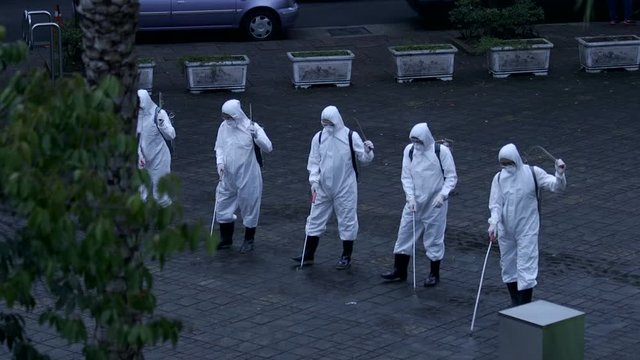 New coronaviruses, COVID-19. People wearing protective suits spraying chemical drugs to disinfect public place of enclosed communities. Taking precautions during the pandemic