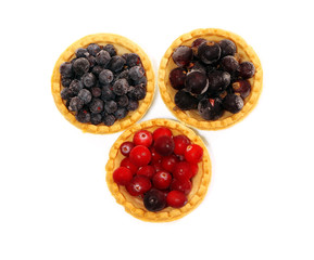 Tasty tartlets with different berries,cranberries,bilberry and blackcurrant isolated. Berry tartlets. Cake with berries. Dessert with berries. Wooden background.Healthy food, vitamins.