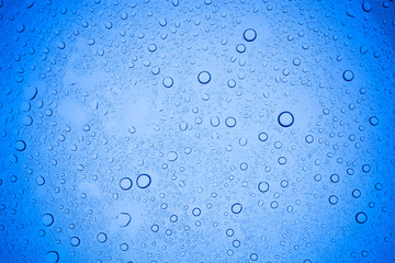 Rain droplets on blue glass background, Water drops on blue glass.