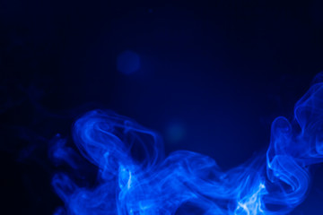 Blue smoke on black background.
