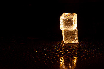 Golden ice cubes on black background.