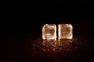 Golden ice cubes on black background.