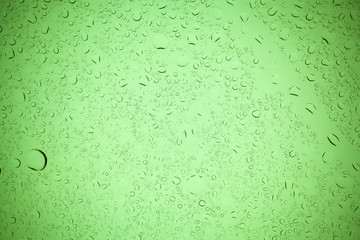 Rain droplets on green glass background, Water drops on green glass.
